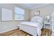 Cozy bedroom with white shutter bed, wood floors, and window with blinds at 1005 Ketzal Dr, Trinity, FL 34655