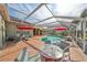 Inviting kidney-shaped pool with red umbrellas and screened patio at 1120 Signature Dr, Sun City Center, FL 33573