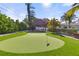 Landscaped backyard putting green with thatched roof hut at 1217 De Narvaez Ave, Bradenton, FL 34209