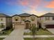 Two-story house with beige siding, stone accents, and a two-car garage at 12643 Horseshoe Bend Dr, Lithia, FL 33547