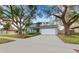 Gray house with blue door, large trees, and driveway at 16013 Eagle River Way, Tampa, FL 33624