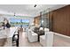 Modern dining area with glass table and white chairs, near kitchen and living room at 17059 Dolphin Dr, North Redington Beach, FL 33708