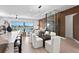 Modern dining area with glass table and white chairs, near kitchen and living room at 17059 Dolphin Dr, North Redington Beach, FL 33708