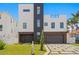 Modern home with a three-car garage and landscaped yard at 17059 Dolphin Dr, North Redington Beach, FL 33708