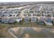 Aerial view of neighborhood with houses and lake at 18079 Ramble On Way, Land O Lakes, FL 34638