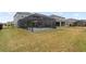 Large backyard with covered patio, screened enclosure, and grassy area at 18079 Ramble On Way, Land O Lakes, FL 34638