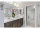 Elegant bathroom with double vanity, large mirror, and walk-in closet at 18079 Ramble On Way, Land O Lakes, FL 34638