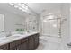 Modern bathroom with double vanity, large shower, and white tile floors at 18079 Ramble On Way, Land O Lakes, FL 34638