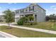 Two-story house with gray siding, landscaping, and a paved driveway at 18079 Ramble On Way, Land O Lakes, FL 34638