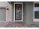 Modern front door with glass panels and a wreath at 18079 Ramble On Way, Land O Lakes, FL 34638