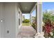 Covered porch with stone tile flooring and tropical plants at 18079 Ramble On Way, Land O Lakes, FL 34638