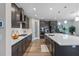 Modern kitchen features island, stainless steel appliances, and dark cabinetry at 18079 Ramble On Way, Land O Lakes, FL 34638