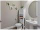 Chic powder room with pedestal sink, toilet and decorative mirror at 18079 Ramble On Way, Land O Lakes, FL 34638