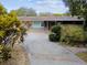 Front yard with circular driveway and mature shrubs at 1824 Southwood Ln, Clearwater, FL 33764