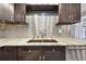 Kitchen features granite countertops, dark cabinets and a double sink at 1824 Southwood Ln, Clearwater, FL 33764