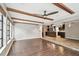 Open concept living room with kitchen view, hardwood floors and wood beams at 1824 Southwood Ln, Clearwater, FL 33764