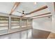 Bright living room featuring hardwood floors, wood beams, and multiple windows at 1824 Southwood Ln, Clearwater, FL 33764