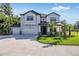 Two-story house with three-car garage, stone accents and lush landscaping at 18437 Purple Creek Ln, Lutz, FL 33549