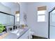 Modern bathroom with gray vanity, black faucets, and glass shower at 22223 Woodmen Hall Dr, Land O Lakes, FL 34637