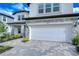 Two-story house with gray stone accents, white garage door, and landscaped walkway at 22223 Woodmen Hall Dr, Land O Lakes, FL 34637