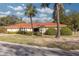 Single story home with red tile roof, landscaping, and palm trees at 2430 Roberta Ln, Clearwater, FL 33764