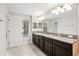 Bathroom with granite countertop, double sinks, and large mirror at 28523 Pleasant Bay Loop, Wesley Chapel, FL 33543