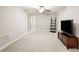 Spacious bonus room features carpet, ceiling fan, and TV stand at 28523 Pleasant Bay Loop, Wesley Chapel, FL 33543