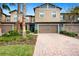 Tan two-story townhome with brown garage doors and landscaping at 28523 Pleasant Bay Loop, Wesley Chapel, FL 33543