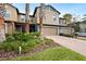 Tan two-story townhome with palm trees and a brick driveway at 28523 Pleasant Bay Loop, Wesley Chapel, FL 33543