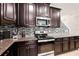 Kitchen with dark wood cabinets, granite countertops, and stainless steel appliances at 28523 Pleasant Bay Loop, Wesley Chapel, FL 33543