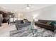 Living room with kitchen view, gray sofas and a coffee table at 28523 Pleasant Bay Loop, Wesley Chapel, FL 33543