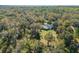Aerial view of a house nestled in a wooded area with a fire pit at 31445 Amberlea Rd, Dade City, FL 33523