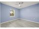 Light blue bedroom with wood-look floors and window at 31445 Amberlea Rd, Dade City, FL 33523