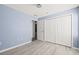 Light blue bedroom with wood-look floors and large closet at 31445 Amberlea Rd, Dade City, FL 33523