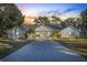White house exterior at sunset, palm trees, and long driveway at 31445 Amberlea Rd, Dade City, FL 33523