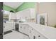 White kitchen with green wall and stainless steel appliances at 31445 Amberlea Rd, Dade City, FL 33523