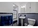 Clean bathroom with pedestal sink, shower, and updated gray tile at 3282 Honeysuckle Rd, Largo, FL 33770