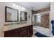 Bathroom with double sinks, granite countertops, and a walk-in shower at 3282 Honeysuckle Rd, Largo, FL 33770