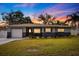 Updated single-story home with gray and blue exterior, landscaping, and a white garage door at 3282 Honeysuckle Rd, Largo, FL 33770
