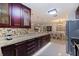 Modern kitchen with dark wood cabinets, granite countertops, and stainless steel appliances at 3282 Honeysuckle Rd, Largo, FL 33770