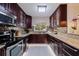 Modern kitchen featuring granite countertops, stainless steel appliances, and dark wood cabinetry at 3282 Honeysuckle Rd, Largo, FL 33770
