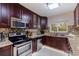 Modern kitchen with dark wood cabinets, granite countertops, and stainless steel appliances at 3282 Honeysuckle Rd, Largo, FL 33770
