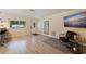Living room features hardwood floors, a comfy chair, and a large TV at 3282 Honeysuckle Rd, Largo, FL 33770