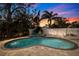 Kidney-shaped pool with stone deck and landscape lighting in the backyard at 3282 Honeysuckle Rd, Largo, FL 33770
