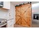 Modern kitchen with white shaker cabinets and a wood barn door at 3445 Briar Cliff Dr, Holiday, FL 34691