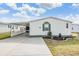 Front view of a white manufactured home with carport and landscaping at 37538 New Horizons Blvd, Zephyrhills, FL 33541