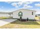 White single-wide manufactured home with carport, landscaping, and a paved driveway at 37538 New Horizons Blvd, Zephyrhills, FL 33541