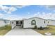 Single-wide manufactured home with carport and landscaping at 37538 New Horizons Blvd, Zephyrhills, FL 33541