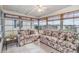 Relaxing sunroom with tiled floor and floral patterned sofas at 37538 New Horizons Blvd, Zephyrhills, FL 33541
