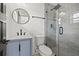 Bathroom featuring blue vanity, stylish lighting, and glass shower with gray tile at 407 41St Ave, St Pete Beach, FL 33706